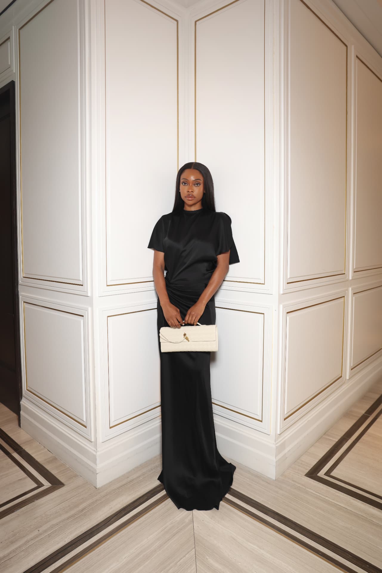 Lateefat Ayinde photographed full-length in a floor-length black satin gown